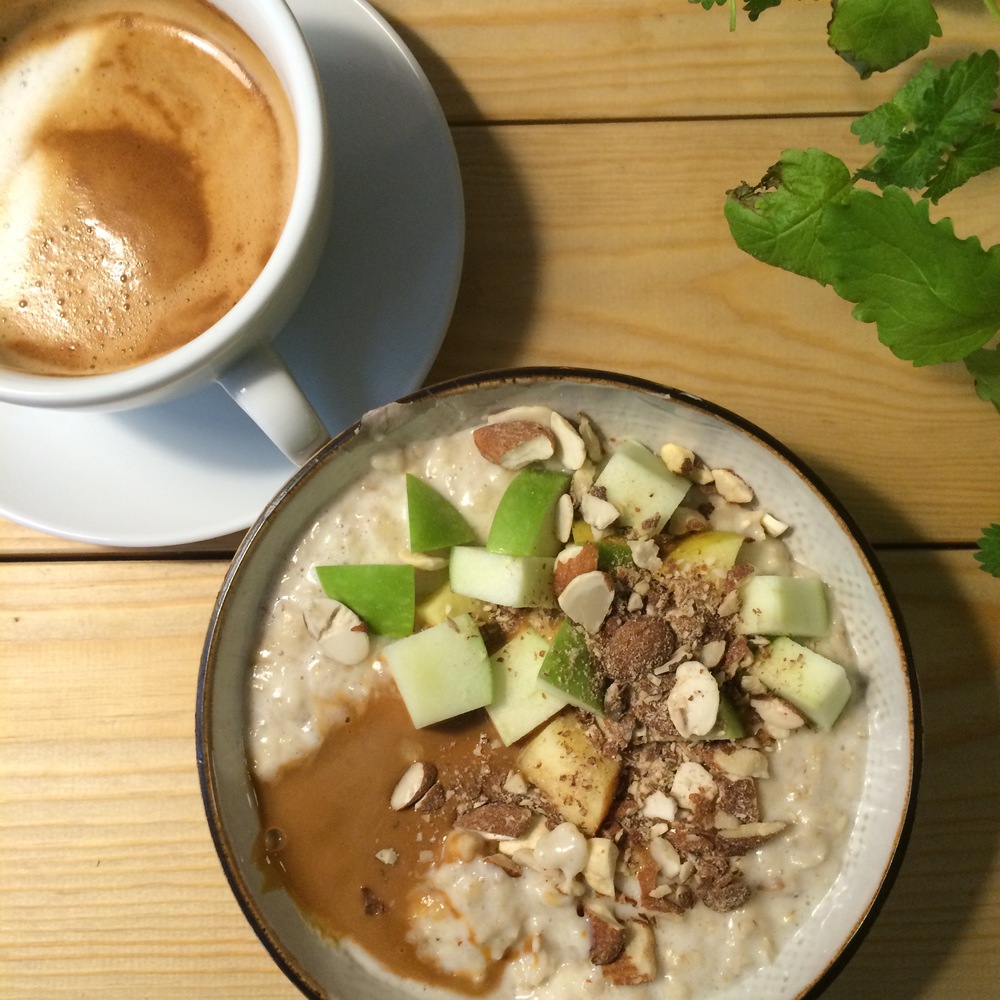 A bowl of oat porridge with fresh apple and caramel sauce. Yum.