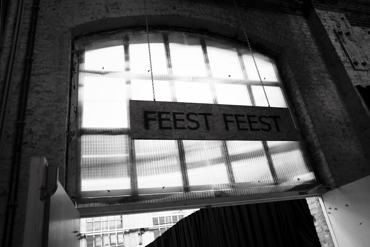 A sign over a door that says "FEEST FEEST"