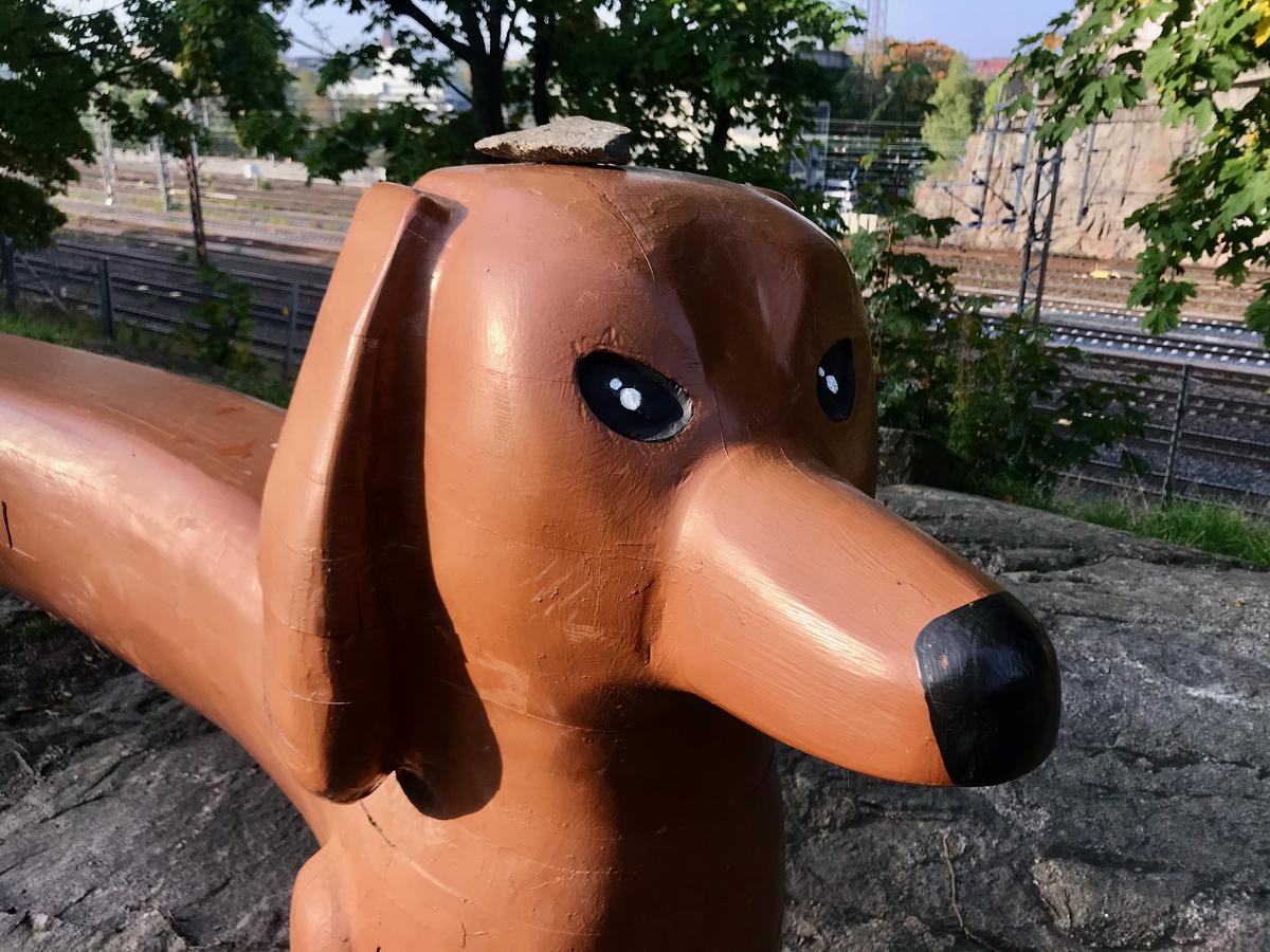 A close up of the head of a weiner dog sculpture. The dog looks intense.